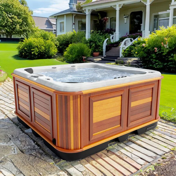 Arctic Spas Cub compact hot tub with dark cabinet beside a brick wall and pool