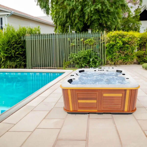 Arctic Spas Kodiak hot tub with open shell and headrests in a garden setting