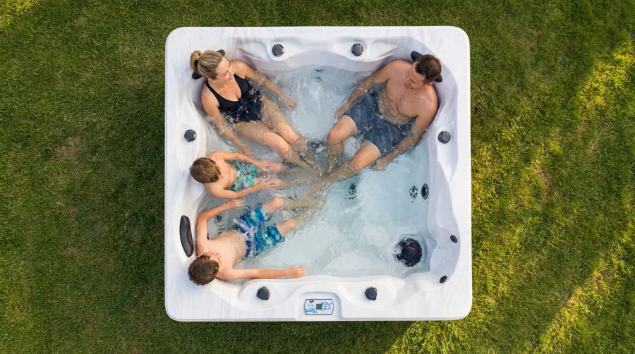 Arctic Spas Nova hot tub with bather relaxing at the waterline at dusk