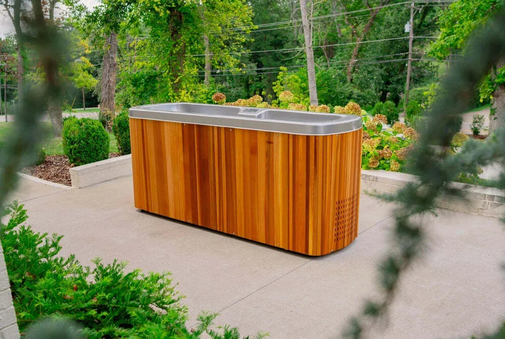 Icebreaker two-person cold plunge tub beside a pool with tropical planting