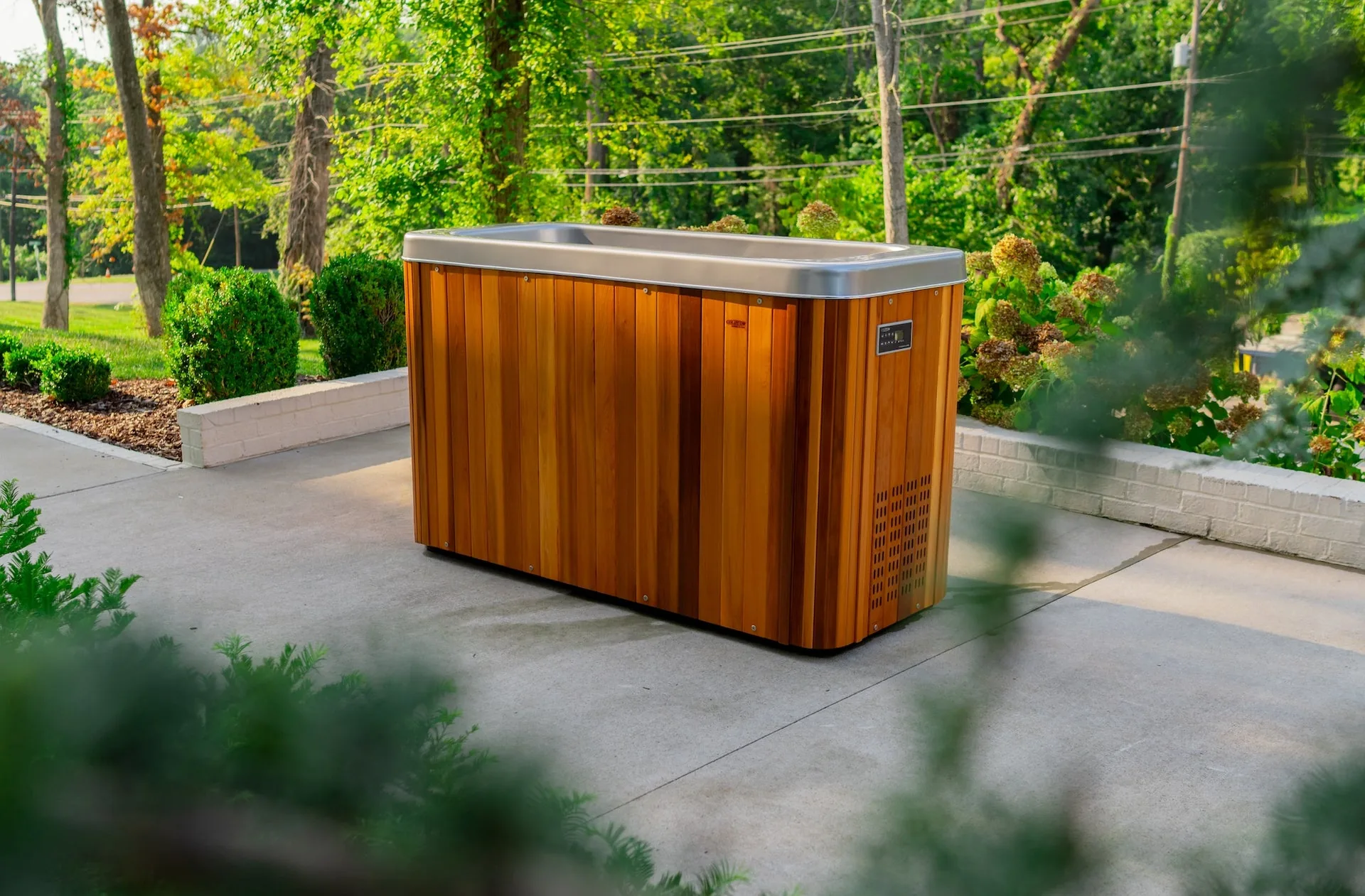 Icepod Plus cold plunge with wood cladding beside sun loungers on a pool deck