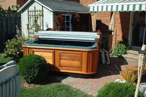 Well-maintained hot tub with clear water on a timber deck at golden hour