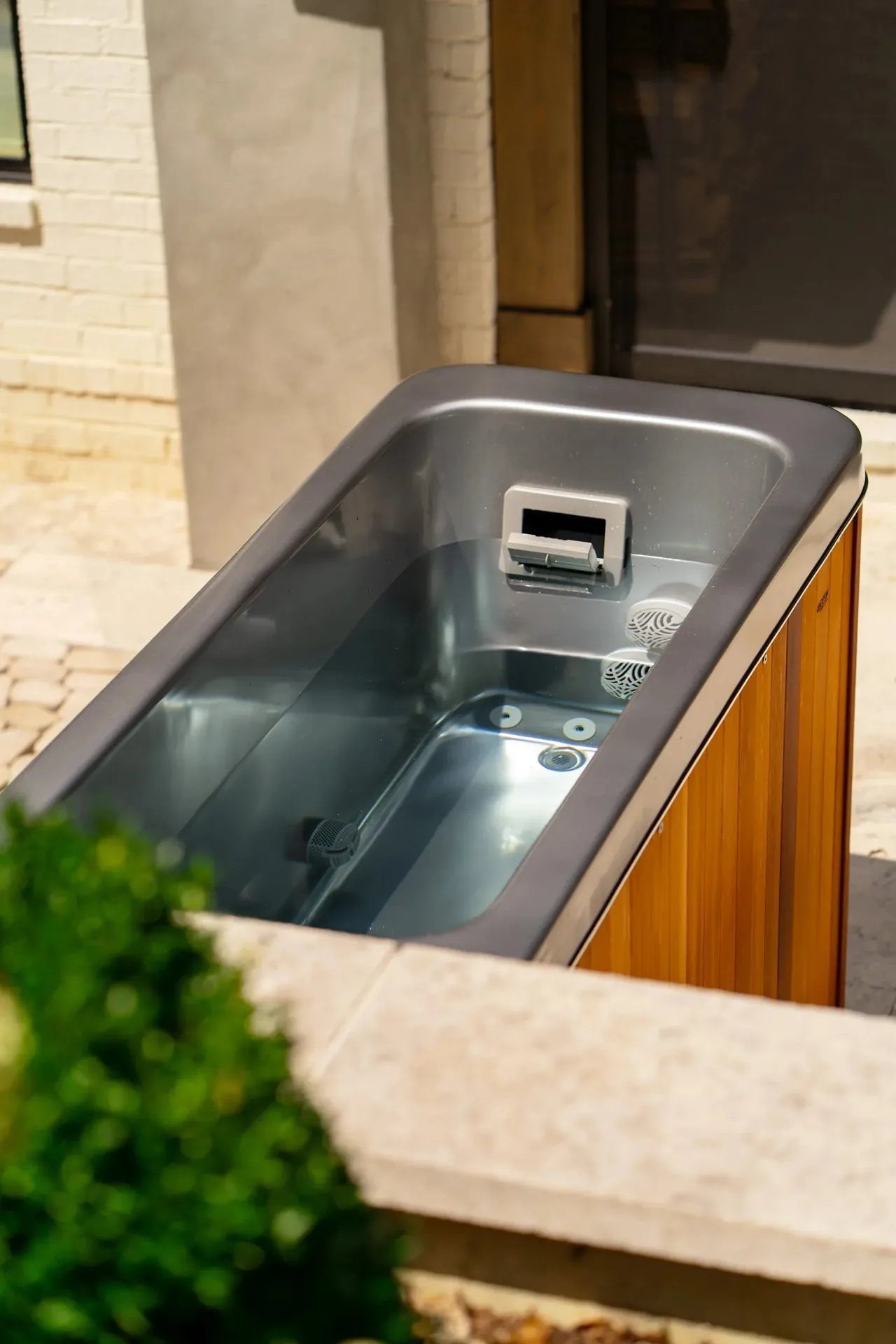 Cold plunge tub integrated under a pergola in a tropical North Miami garden