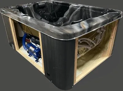 Technician connecting hot tub equipment inside the cabinet bay