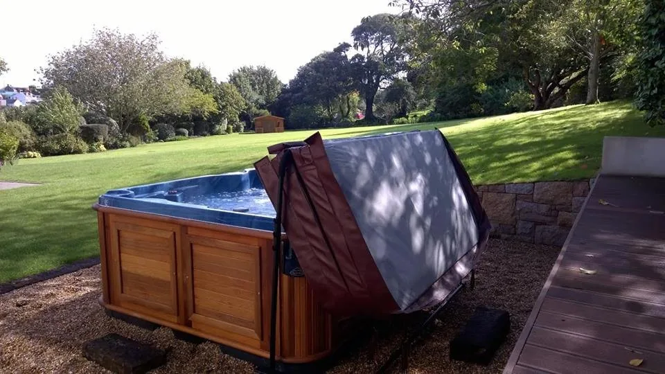 Hot tub with a freshly fitted insulated cover folded open on a clean shell