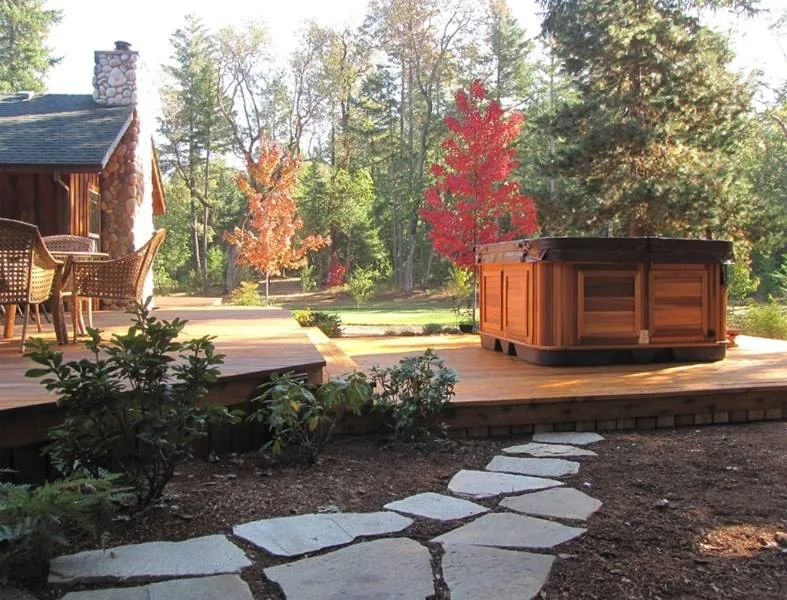 Compact hot tub in a private walled townhouse courtyard with turf and palms