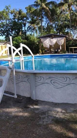 Compact round aboveground pool with steps in a fenced Florida backyard