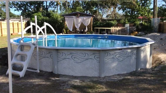 Round aboveground pool with entry ladder and handrail in a garden setting